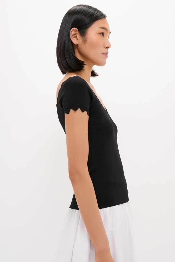 Woman wearing the Black Off-the-Shoulder Ric Rac Compression Elliston Shirt, showcasing its classic slim fit and chic ric-rac detailing for an effortless, high-end style.