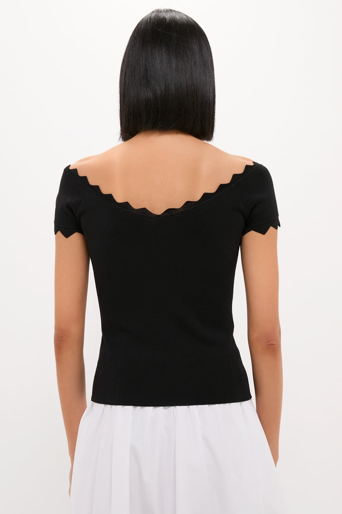 Person wearing a classic Black Off-the-Shoulder Ric Rac Compression Elliston Shirt, showcasing its effortless and fun scalloped neckline and chic slim fit.