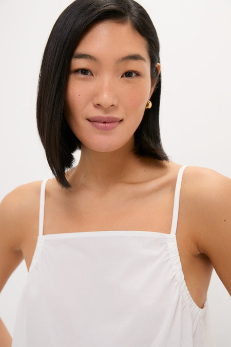Young woman wearing the classic, high-end White Cotton Poplin Mandi Top with spaghetti straps, embodying an effortless and fun style.
