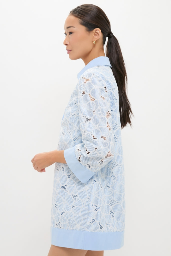 Young woman in profile wearing the classic Blue Floral Lace Collier Dress with a lacy floral overlay, exuding an effortless, high-end style perfect for fun summer occasions.