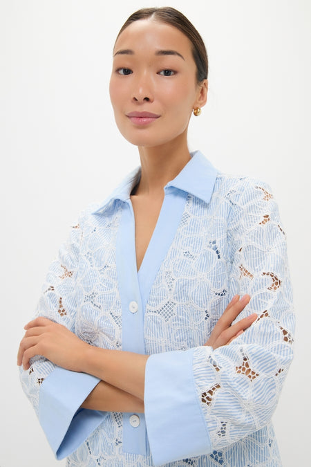 Woman wearing Blue Floral Lace Collier Dress with white lace details, exuding a classic and effortless style, accessorized with gold hoop earrings for a high-end, fun look.