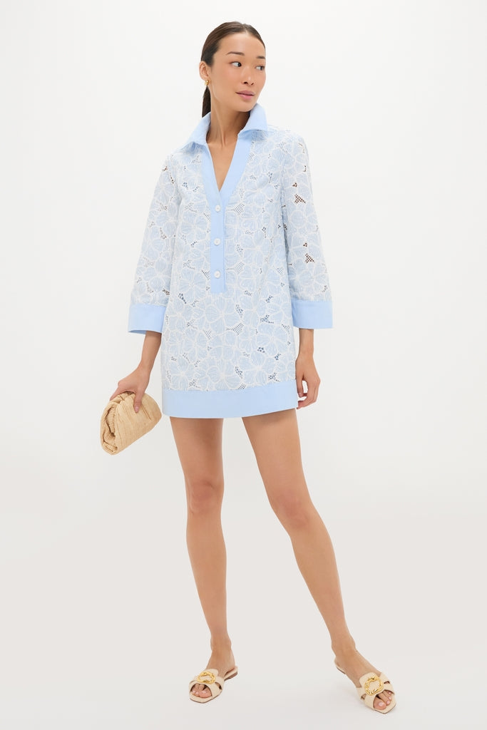 Model wearing classic Blue Floral Lace Collier Dress with effortless style; features three-quarter sleeves, popped collar, and straw clutch, embodying fun, high-end fashion.