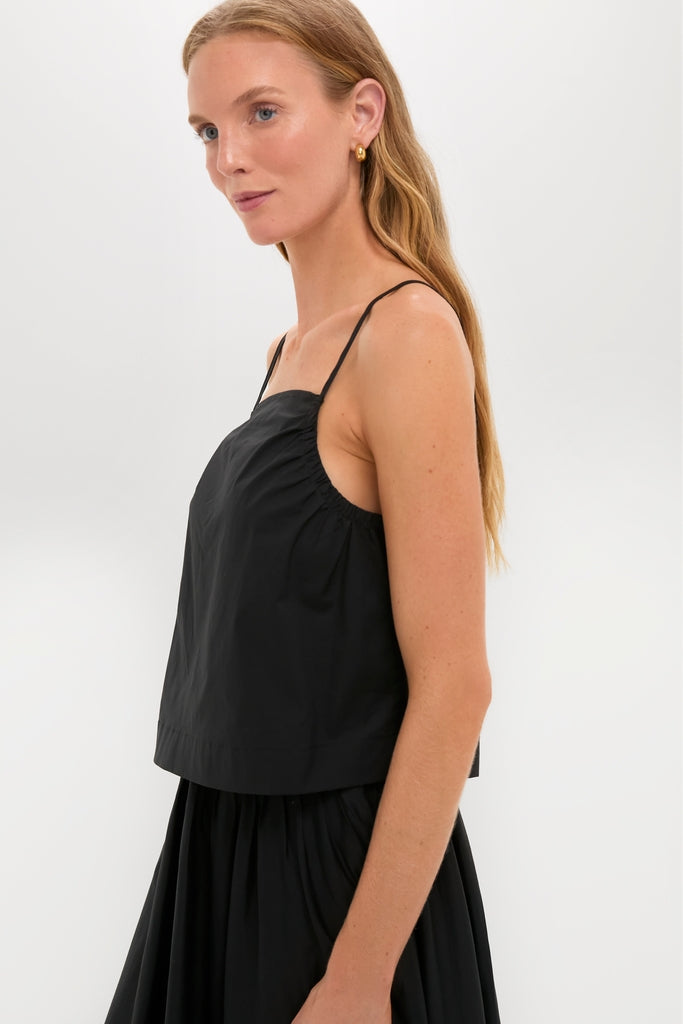 Woman in Black Cotton Poplin Mandi Top, showcasing a classic, effortless look with thin straps and minimalist design, embodying Tuckernuck's high-end, fun, and confident style.