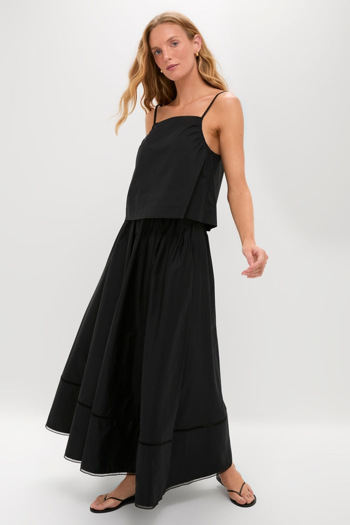 Black Cotton Poplin Mandi Top modeled with classic elegance, showcasing an effortless, high-end look with fun, flowing design and versatile spaghetti straps.