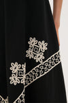 Soutache Cotton Andrea Circle Skirt, featuring classic, high-end white rope-style embroidery with flower motifs on a textured black panel, exuding an effortless and fun style.