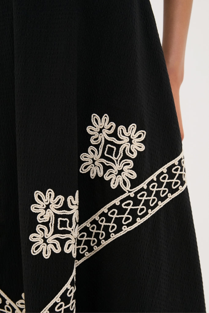 Soutache Cotton Andrea Circle Skirt, featuring classic, high-end white rope-style embroidery with flower motifs on a textured black panel, exuding an effortless and fun style.
