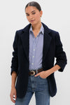 Young woman models the Navy Boucle Leo Blazer, a classic, effortless piece with a modern edge, showcasing its oversized fit and peak lapels for a high-end, fun style.