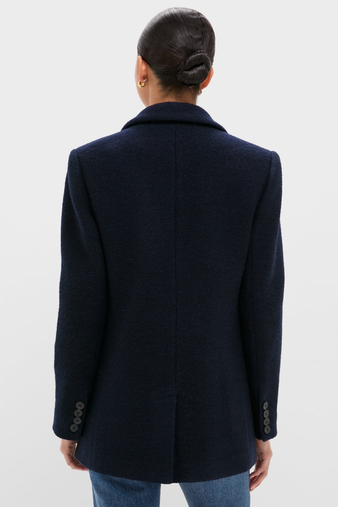 Woman in a classic Navy Boucle Leo Blazer with tailored fit, notched lapels, and buttoned cuffs, paired with jeans. Effortless, high-end style.