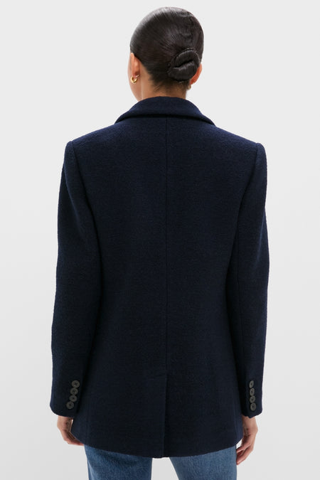 Woman in a classic Navy Boucle Leo Blazer with tailored fit, notched lapels, and buttoned cuffs, paired with jeans. Effortless, high-end style.