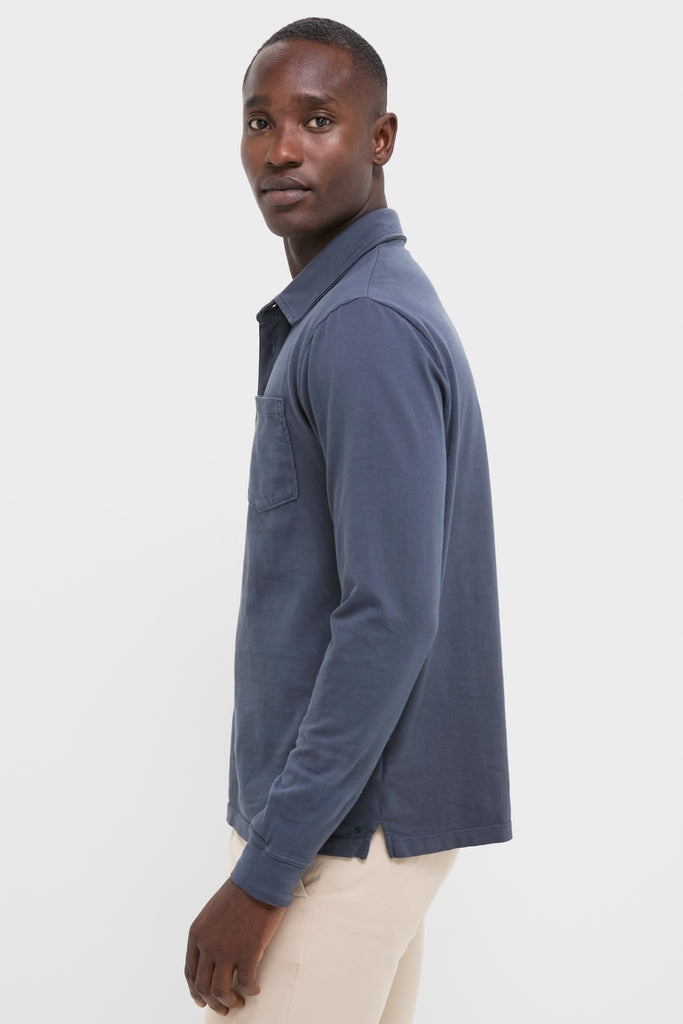 Young man models the Faded Navy Garment Dyed Long Sleeve Polo, a classic, effortless piece for versatile, high-end style, crafted from soft Pima cotton.