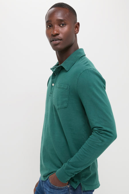 Young man models the Washed Pine Long Sleeve Hudson Polo, showcasing its classic, effortless style with a front chest pocket and three-button placket, paired with blue jeans.