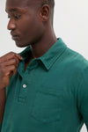Person wearing the Washed Pine Long Sleeve Hudson Polo, showcasing its classic, effortless style with a chest pocket and three-button placket, perfect for high-end, fun occasions.