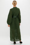 Woman in a classic, floor-length Forest Green Lace Calliope Dress with puffed sleeves and satin sash, embodies effortless elegance and high-end style.