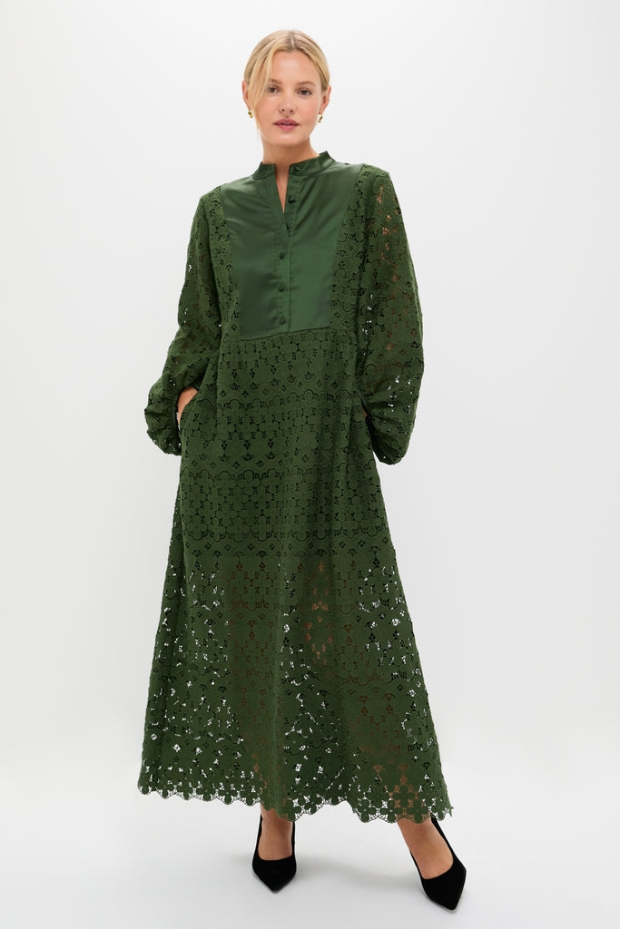Woman wearing the classic Forest Green Lace Calliope Dress with long puffed sleeves, satin-look bib, and scalloped hem, paired with black pointed-toe heels for an effortless, high-end look.