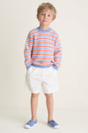 Young boy in Raya Cotton Jumper, showcasing classic intarsia stripes and wooden buttons, embodying effortless, high-end style with a fun, relaxed fit.