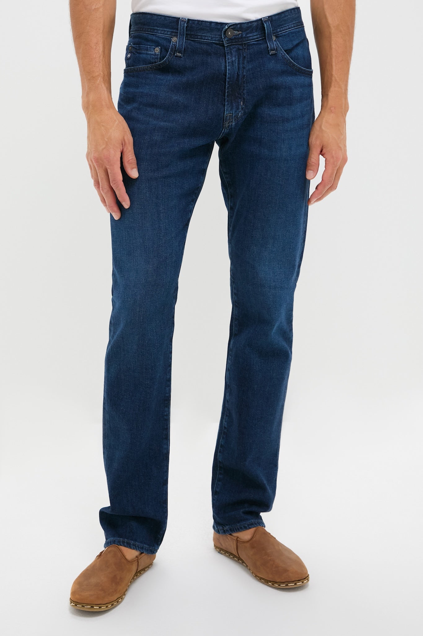 The Graduate in Crusade Wash Denim, a classic slim straight-leg jean, offers an effortless, high-end fit with zip fly and 5-pocket design, paired with tan slip-on shoes.