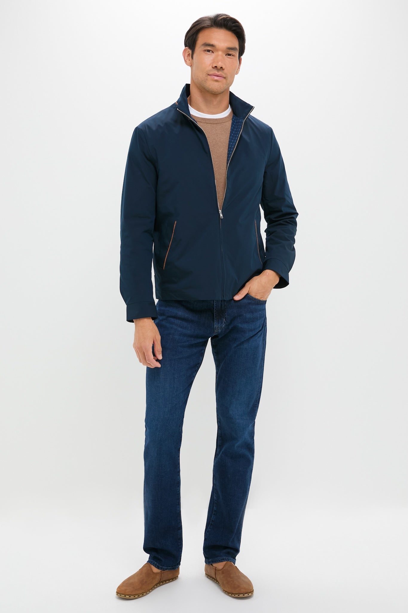 Man in The Graduate in Crusade Wash Denim, showcasing classic, slim-straight fit jeans with effortless style, paired with a navy jacket and brown suede boots.