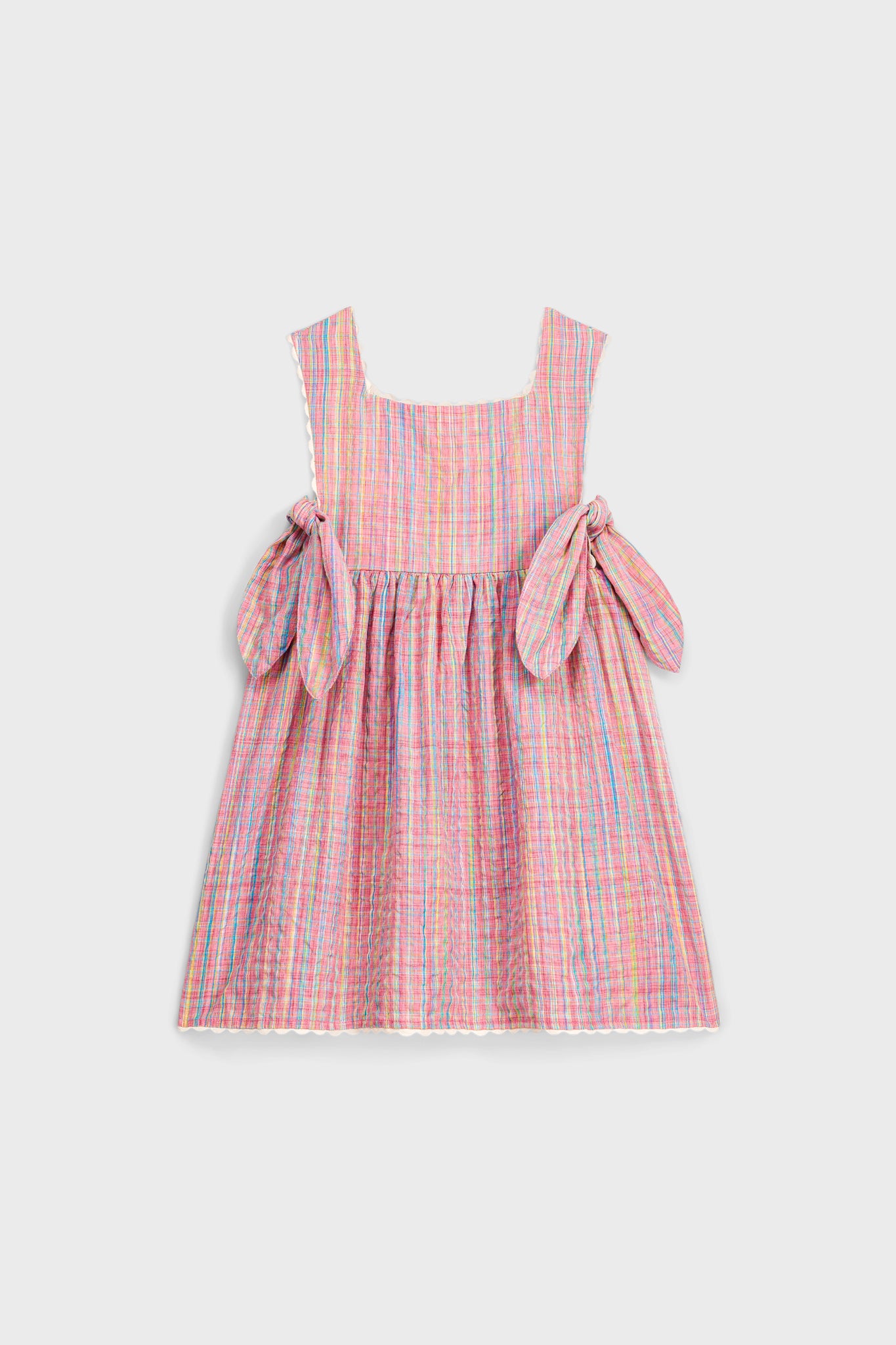 Classic Pink Pomelo Checks Aloisa Dress features an effortless apron design with fun self-ties and high-end ric-rac trim, perfect for stylish spring outings.