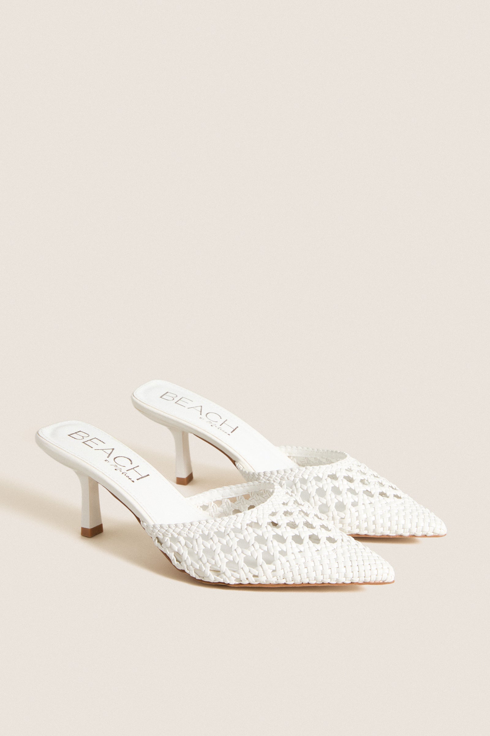 White Tia Heels: Classic pointed-toe, woven mule with kitten heel, offering effortless style for fun occasions or high-end everyday wear. Ideal for versatile, polished looks.