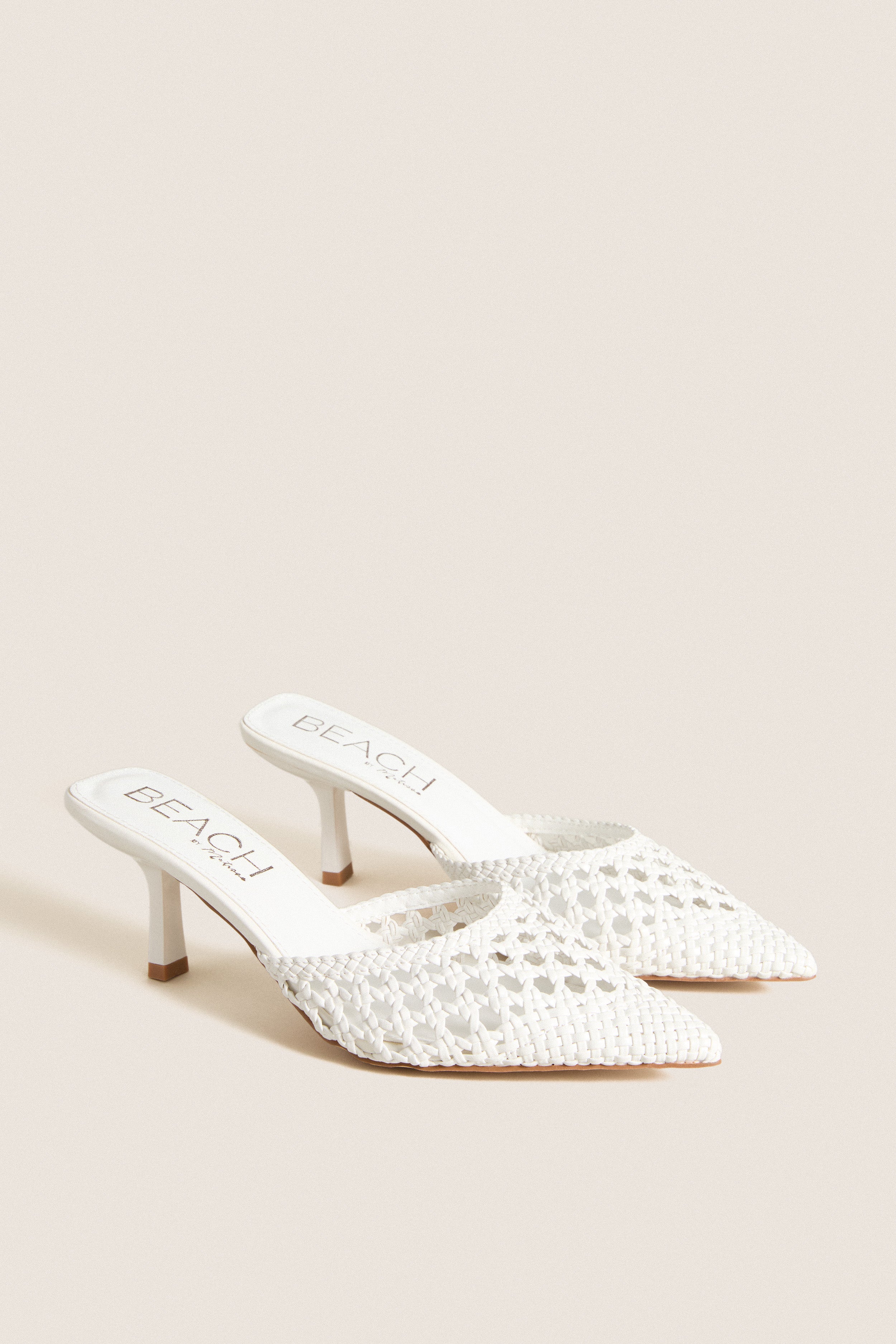 White Tia Heels: Classic pointed-toe, woven mule with kitten heel, offering effortless style for fun occasions or high-end everyday wear. Ideal for versatile, polished looks.