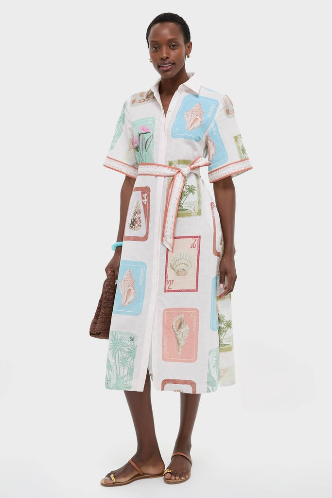 Coastline Shirt Dress: A classic, effortless mid-calf dress with a vintage postage-stamp print, self-tie belt, and camp collar, styled with a woven clutch and sandals.