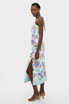 Azure One-Shoulder Midi Dress with vibrant florals, classic thigh-high slit, and mint-green hem, exudes effortless, high-end style; paired with strappy sandals and gold hoops.