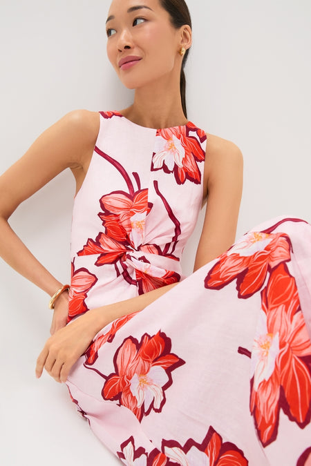 Woman models Lani Maxi Dress, a classic, high-end A-line piece with vibrant floral print and twist detail, styled simply for an effortless, fun look.