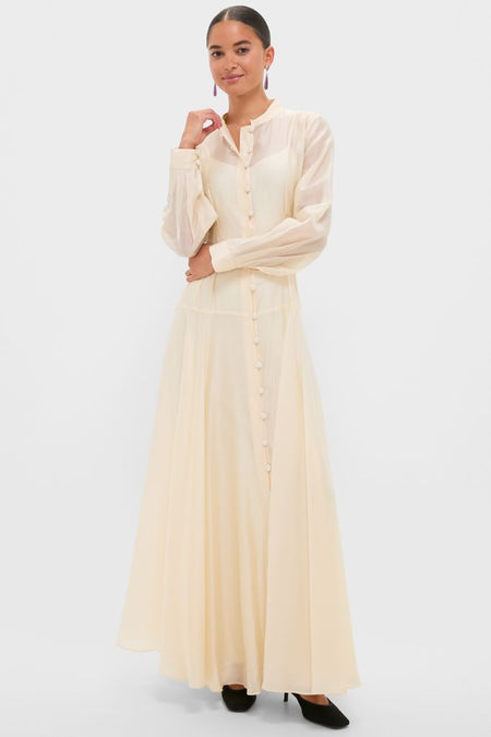 The Champagne Organza Marbella Dress exudes effortless elegance with its classic Mandarin collar, blouson sleeves, and pintucked bodice, perfect for high-end occasions.