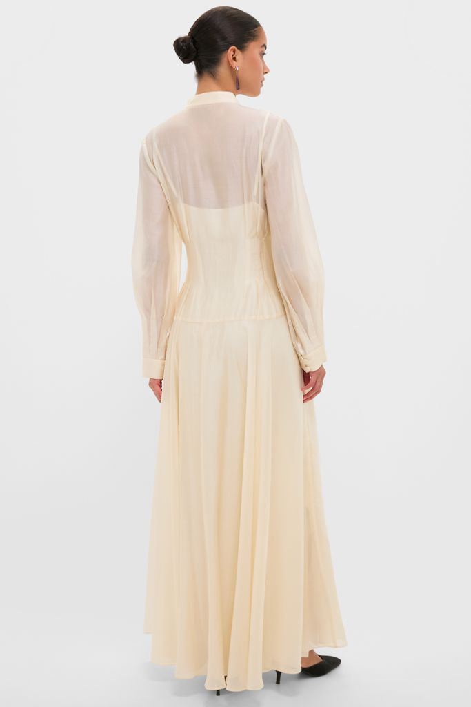 Woman in a classic, high-end Champagne Organza Marbella Dress with Mandarin collar and blouson sleeves, exuding effortless elegance and fun, perfect for sophisticated occasions.