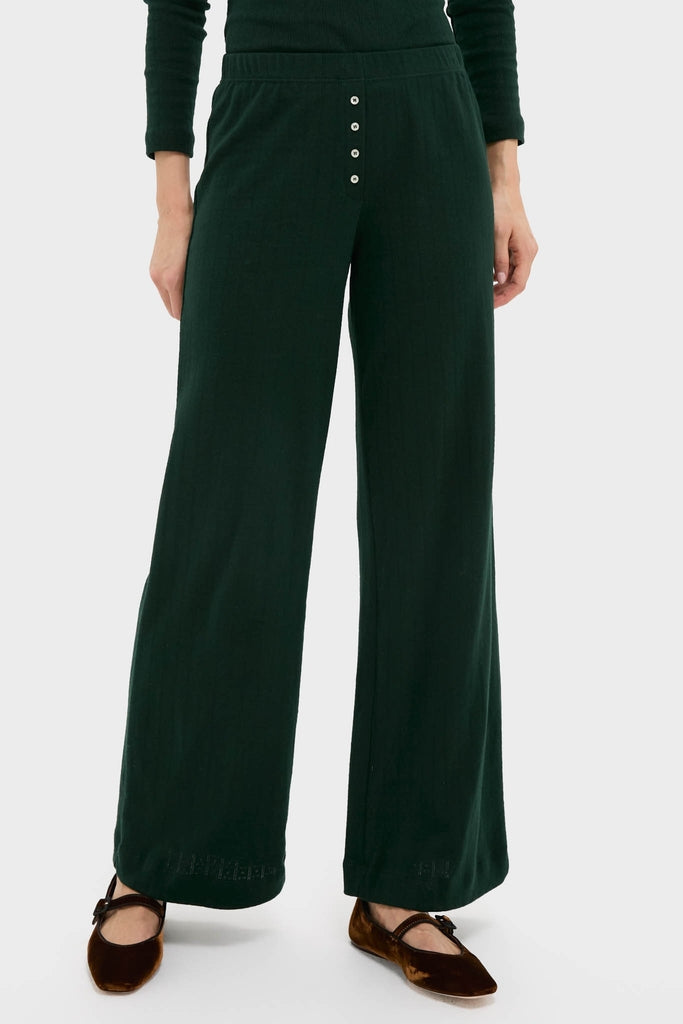 Person wearing classic Forest Pointelle Boxer Pants: dark-green, wide-leg, rib-knit design with elastic waistband, button placket, and brown Mary Jane flats for an effortless, high-end look.