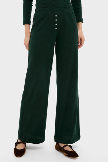 Person wearing classic Forest Pointelle Boxer Pants: dark-green, wide-leg, rib-knit design with elastic waistband, button placket, and brown Mary Jane flats for an effortless, high-end look.