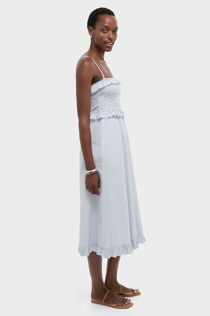 Blue and White Stripe Karine Midi Dress, featuring an effortless, classic design with adjustable straps, smocked bodice, and ruffle trim, styled with flat sandals. Perfect for a fun, high-end look.