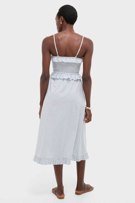 Blue and White Stripe Karine Midi Dress, featuring a classic smocked bodice, ruffle trim, and adjustable straps, styled effortlessly with sandals for a fun, high-end look.