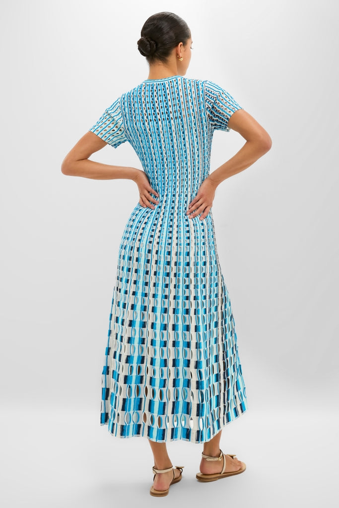 Model wearing the Azure Multi Zaida Midi Dress, showcasing its classic A-line silhouette and intricate geometric knit pattern, styled effortlessly with strappy sandals for a fun, high-end look.