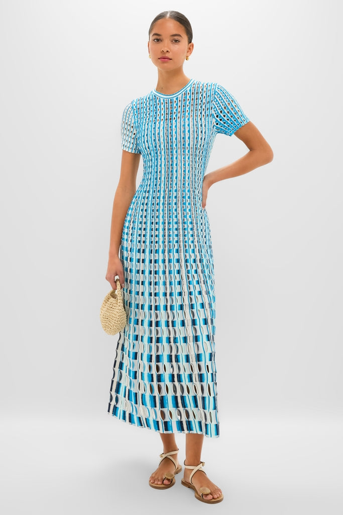 Azure Multi Zaida Midi Dress: A classic, effortless knit dress with a geometric pattern, styled with a round straw handbag and tan sandals for a fun, high-end look.