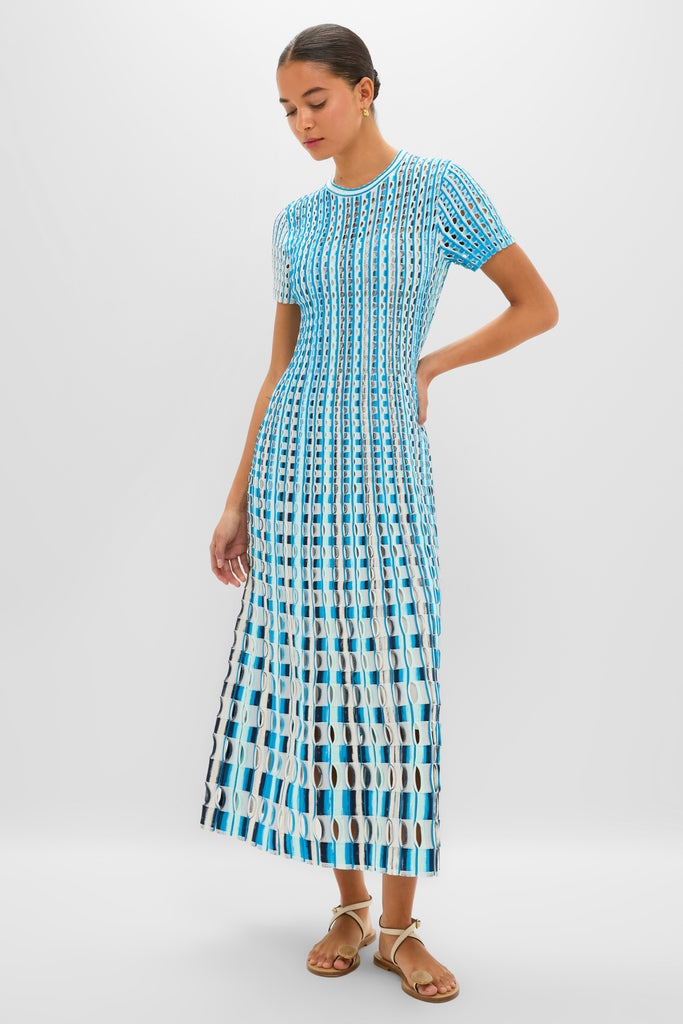 Woman in Azure Multi Zaida Midi Dress, showcasing a classic and effortless geometric knit pattern with oval cut-outs, styled with tan ankle-strap sandals, embodying high-end, fun fashion.