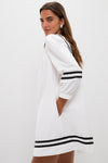 Classic White Palina Mini Dress with black stripe accents on sleeves and hem. Effortless, fun style featuring a pocket, perfect for high-end vacation adventures.
