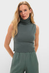Model in Eucalyptus Zoe Sleeveless Turtleneck and loose-fit trousers, showcasing an effortless, high-end style with a classic, fitted foldover turtleneck design.