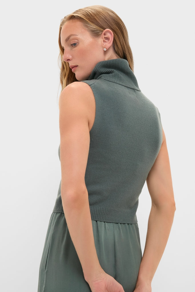 Model wears the Eucalyptus Zoe Sleeveless Turtleneck, a classic, effortlessly stylish piece, showcasing its fitted silhouette and foldover turtleneck for a high-end, fun look.