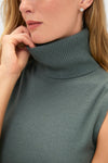 Eucalyptus Zoe Sleeveless Turtleneck in muted teal, worn by a person, showcasing a classic, effortless style with a foldover collar and ribbed texture.