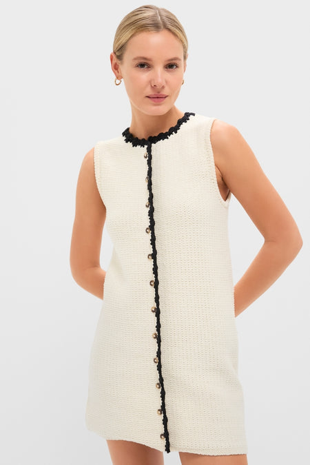 Fashion model showcases the White Knit Lalia Mini Dress, featuring an effortless, high-end style with classic crochet trim and gold buttons, perfect for fun, versatile occasions.