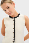 Woman wearing a classic, sleeveless White Knit Lalia Mini Dress with contrasting crochet trim and button placket, embodying effortless, high-end style.
