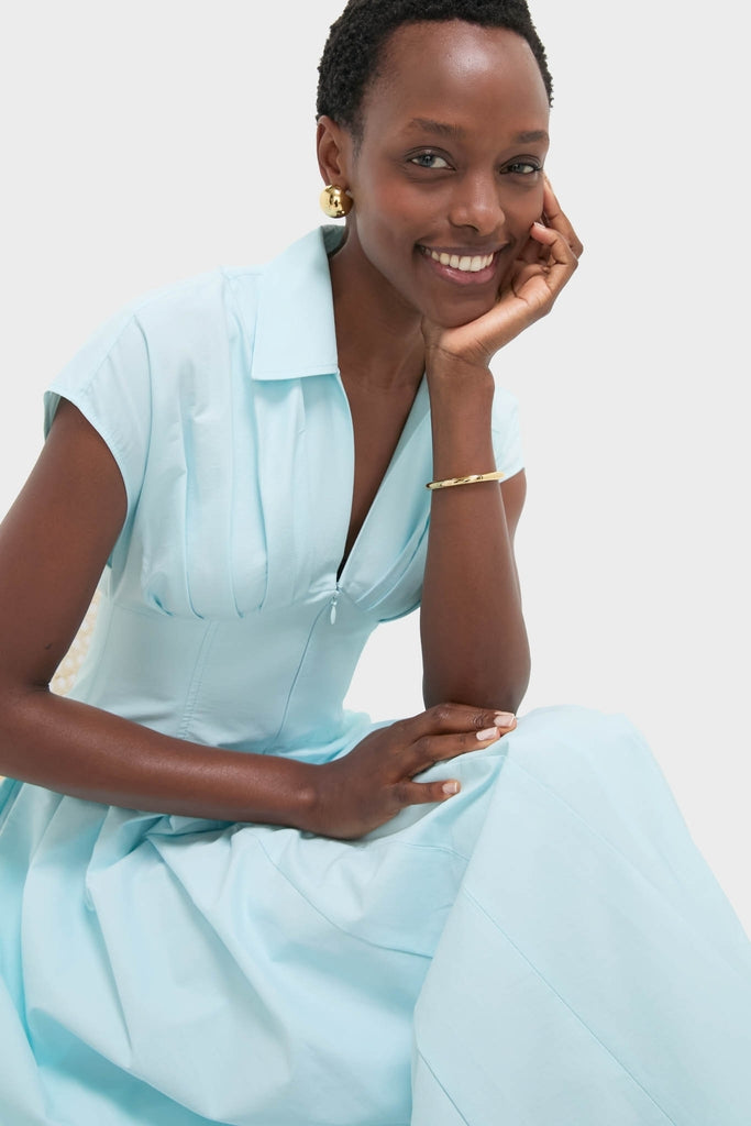 Person wearing the Sky Farlow Midi Dress with classic short sleeves and effortless collar, smiling warmly, accessorized with a gold bracelet and earrings, embodying a fun, high-end style.