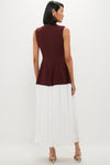 Woman models the Mahogany Multi Raleigh Midi Dress, featuring a classic burgundy peplum top and an effortless white midi skirt, paired with fun, high-end beige sandals.