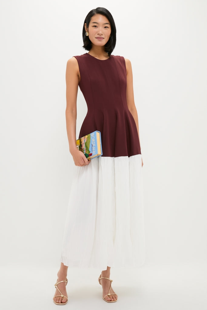 Young woman in Mahogany Multi Raleigh Midi Dress, featuring a classic burgundy peplum top and flowing white skirt, embodies effortless, high-end style with a fun, chic vibe.