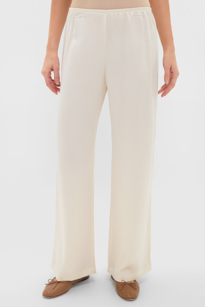 Creme Barb Wide Leg Pants in Japanese-crafted satin, featuring an elastic waistband and relaxed fit, paired with tan ballet flats for a classic, effortless look.