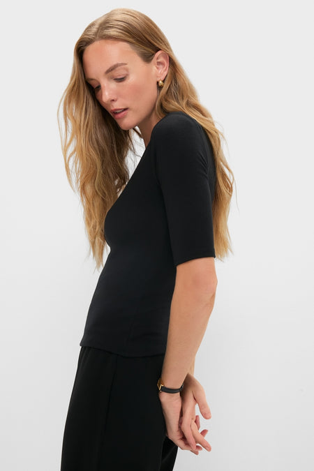 Young woman in profile wearing the classic Black Lauren Mid Sleeve Tee, showcasing its effortless, high-end style with elbow-length sleeves and a crew neckline.