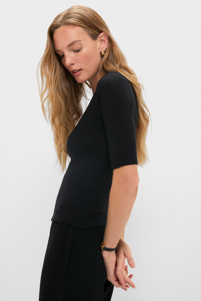 Young woman in profile wearing the classic Black Lauren Mid Sleeve Tee, showcasing its effortless, high-end style with elbow-length sleeves and a crew neckline.