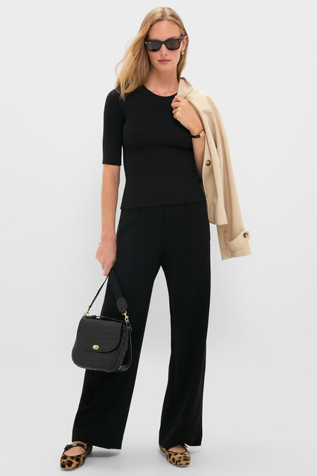 Model wearing the classic Black Lauren Mid Sleeve Tee with wide-leg trousers and leopard-print flats, exuding an effortless, high-end style.