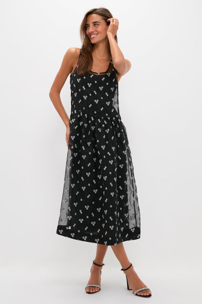 Model in a classic, high-end Black Embroidered Mariella Midi Dress with sequined Mickey Mouse silhouettes, effortlessly styled with ankle-strap sandals for a fun, confident look.
